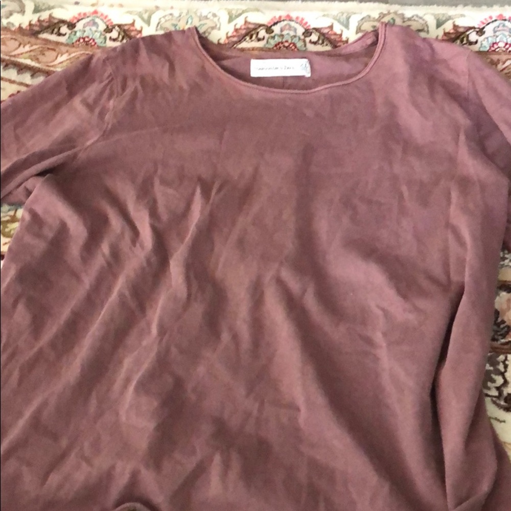 A purple shirt with a flair on the sleeves